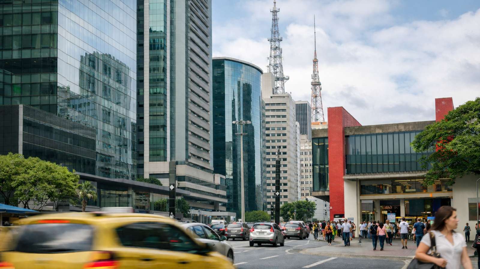 Rua movimentada em centro financeiro brasileiro com prédios comerciais, carros no trânsito e pessoas caminhando nas calçadas.