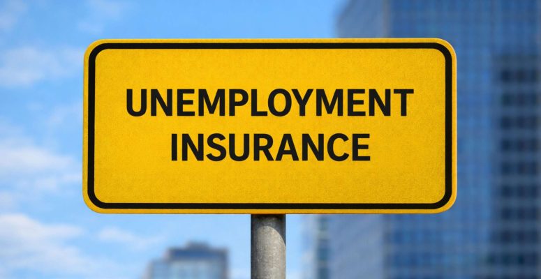 Yellow road-style sign with the words “UNEMPLOYMENT INSURANCE” in bold black letters, mounted on a metal pole, with blurred office buildings in the background.