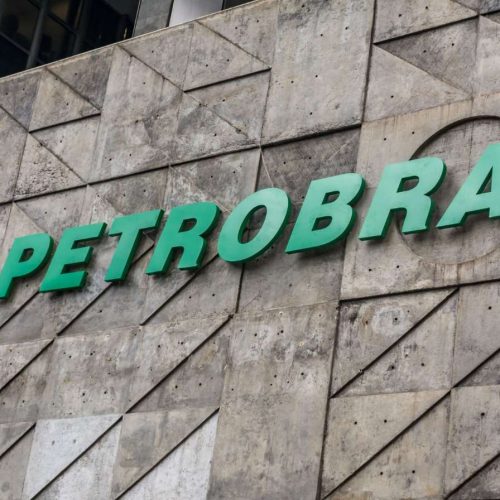 Fachada da Petrobras com logotipo verde e amarelo em prédio de concreto no centro urbano.