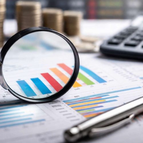 Análise de dados econômicos com gráficos e moedas em mesa de trabalho