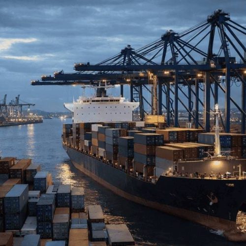 porto com navio cargueiro e containers representando preços de importação EUA e comércio internacional