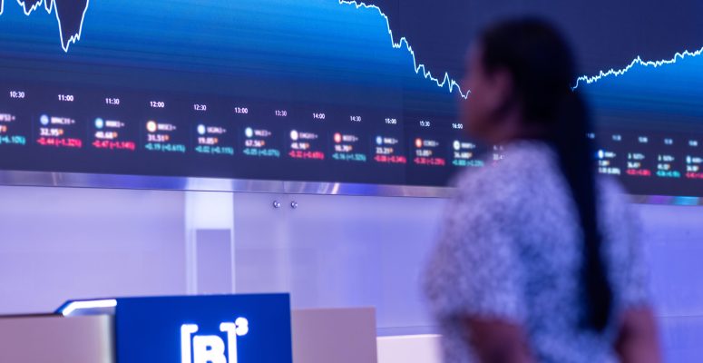 b3Pessoa olhando telão com gráficos e dados financeiros do Banco do Brasil no 1T26.