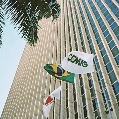 Cemig resultados 4T25 com imagem da sede da empresa e bandeiras do Brasil e da Cemig em frente ao prédio corporativo