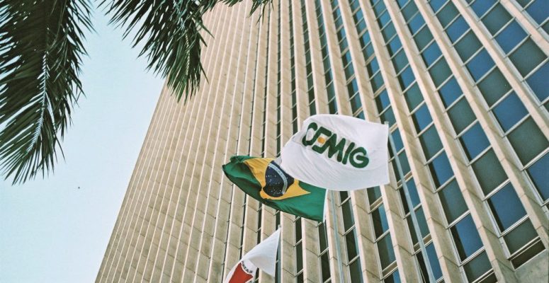 Cemig resultados 4T25 com imagem da sede da empresa e bandeiras do Brasil e da Cemig em frente ao prédio corporativo