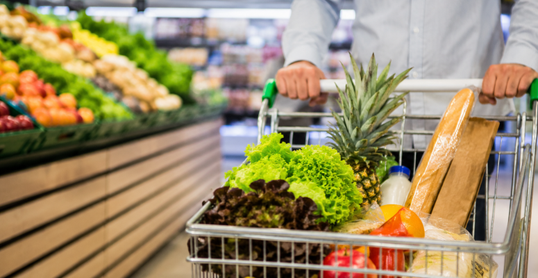 Consumidor faz compras em supermercado com carrinho cheio de alimentos durante alta do IPCA acumulado em 12 meses no Brasil.